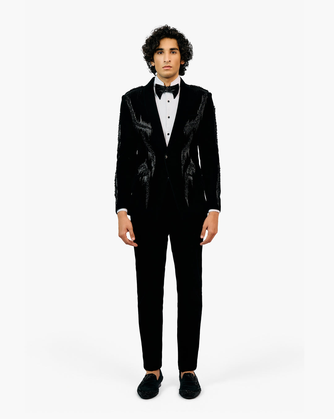Man wearing a black tuxedo with a white shirt and black bow tie by Gaurav Gupta
