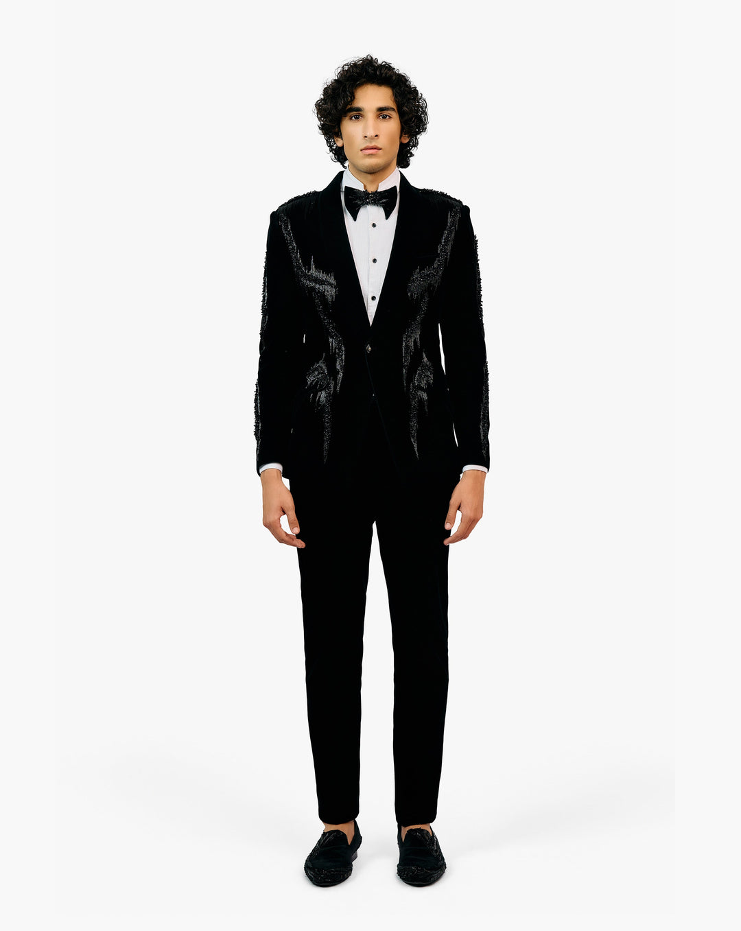 Man wearing a black tuxedo with a white shirt and black bow tie by Gaurav Gupta