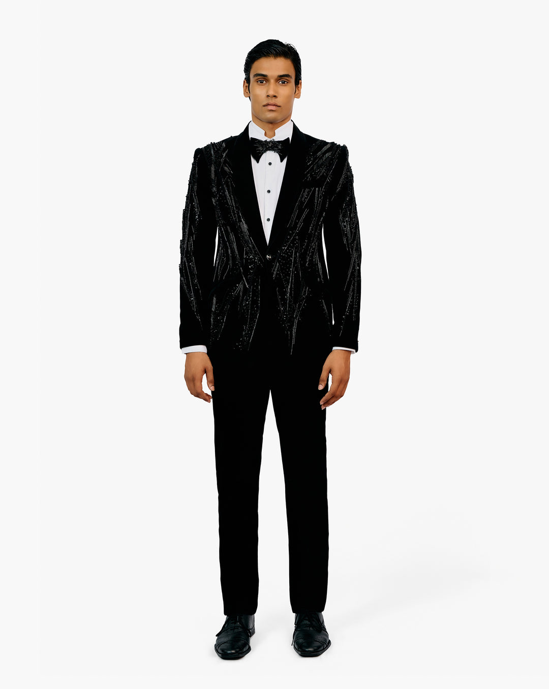 Man wearing a black embroidered tuxedo with a white shirt and bow tie by Gaurav Gupta