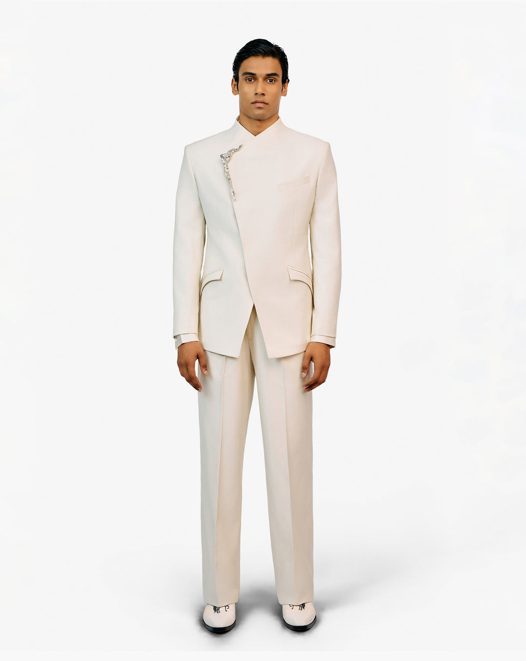 Model wearing a white embroidered sherwani set by Gaurav Gupta