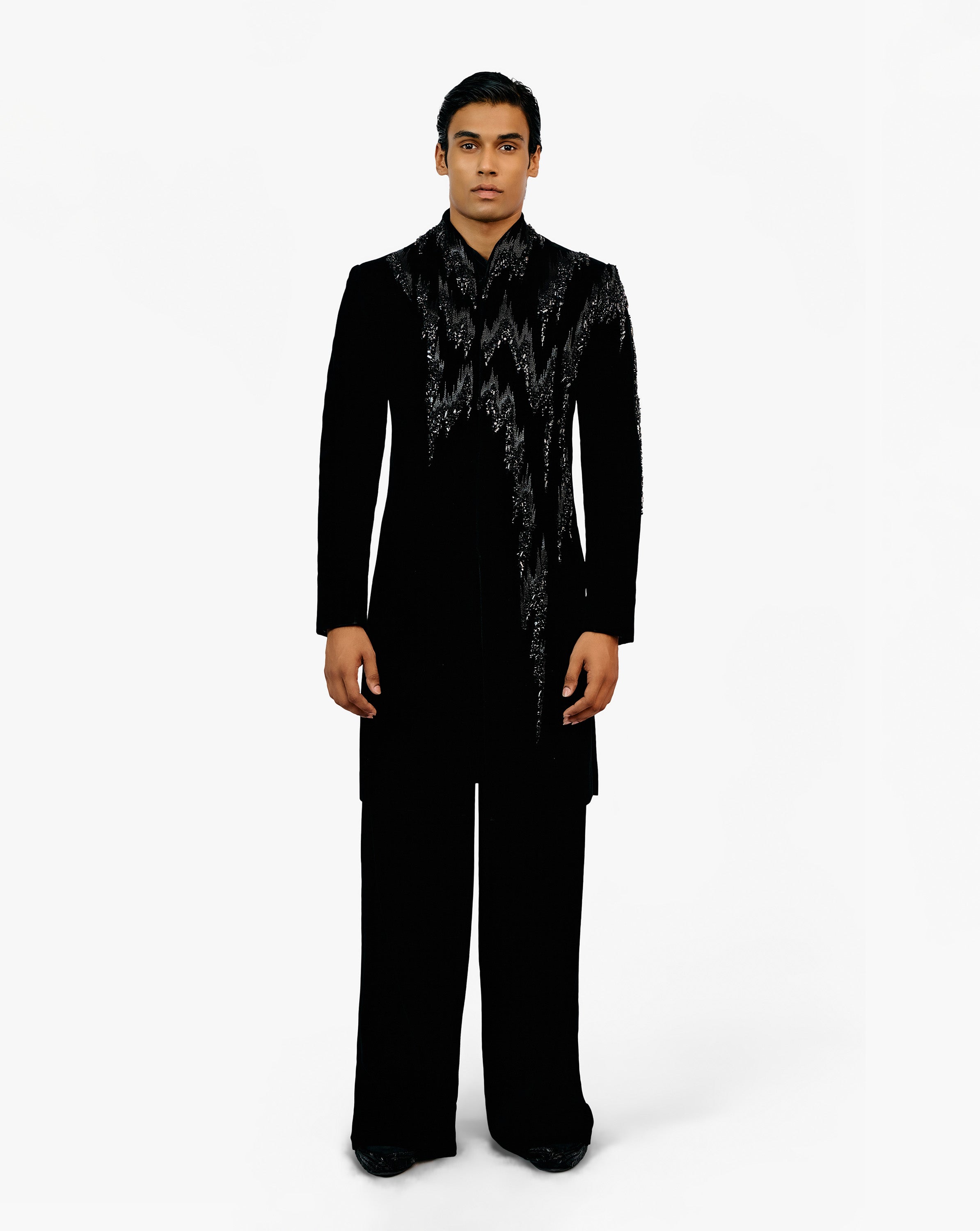 Model wearing a black suit with silver embroidery on it by Gaurav Gupta